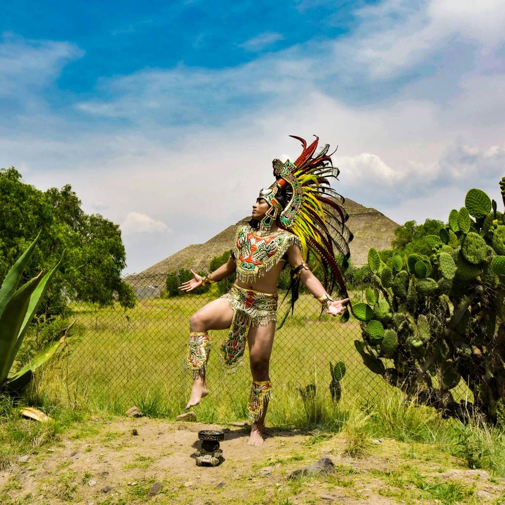 An adult man wearing ceremonial Aztec uniform. 